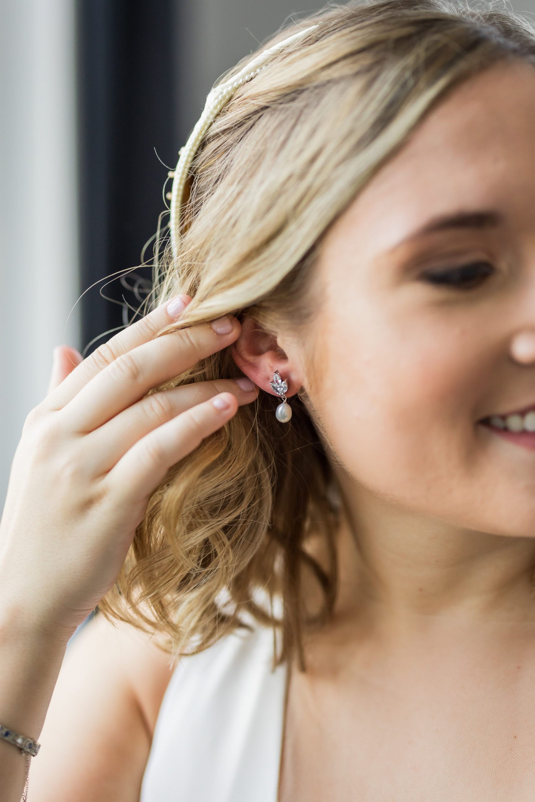 bride brushing hair behind ear showing earrings