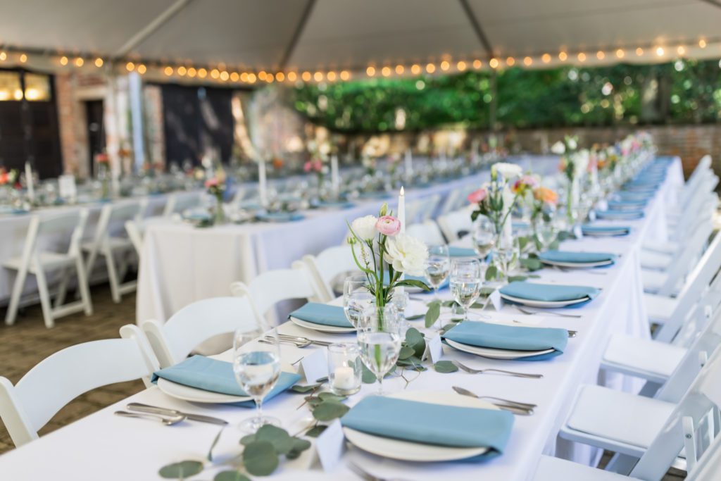 close up of wedding reception tables with white table cloths and blue napkins