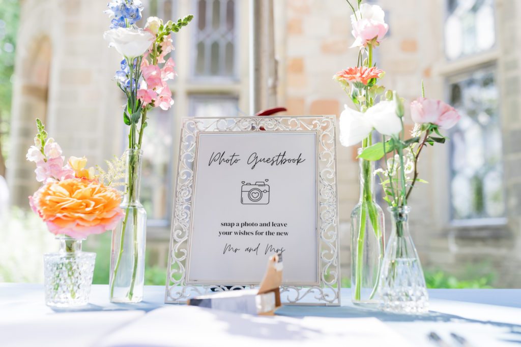 photo guestbook sign with flowers in vase around it