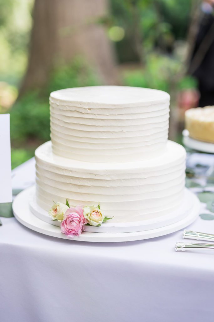 two tiered white wedding cake with pink florals