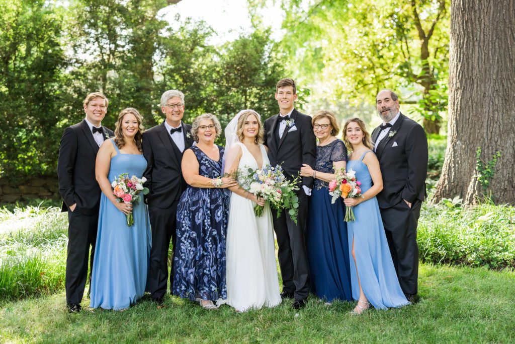 wedding couple standing with family during portraits