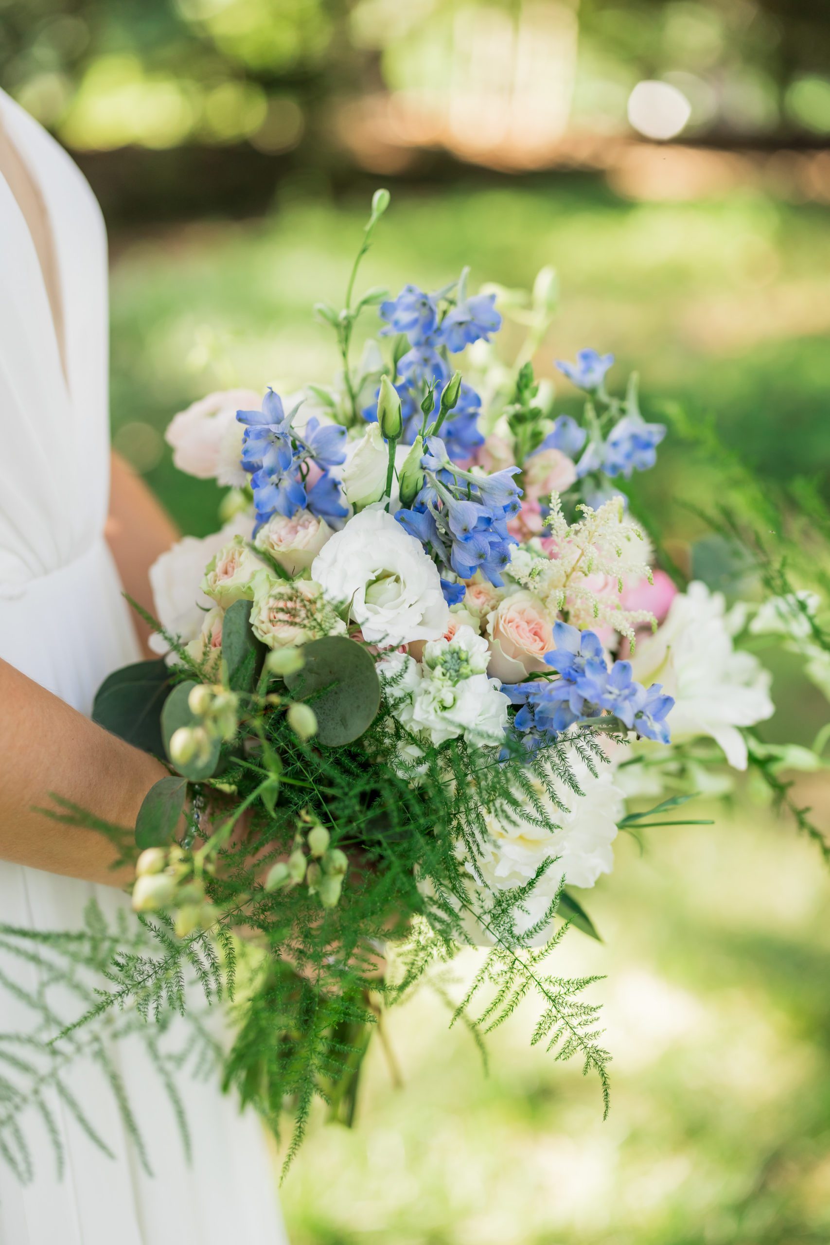close up of bridal bouquet with blue and pink flowers