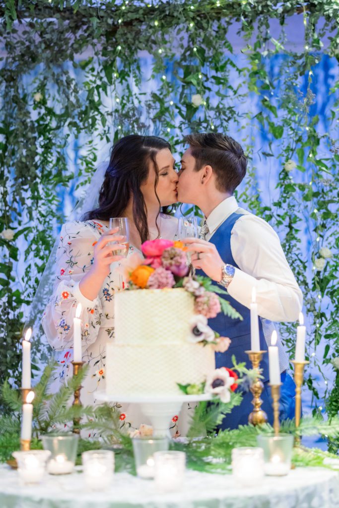 brides kissing after cutting cake at Four Seasons DC Wedding reception