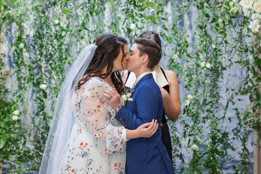 couple kissing after four seasons dc wedding ceremony as newly married partners