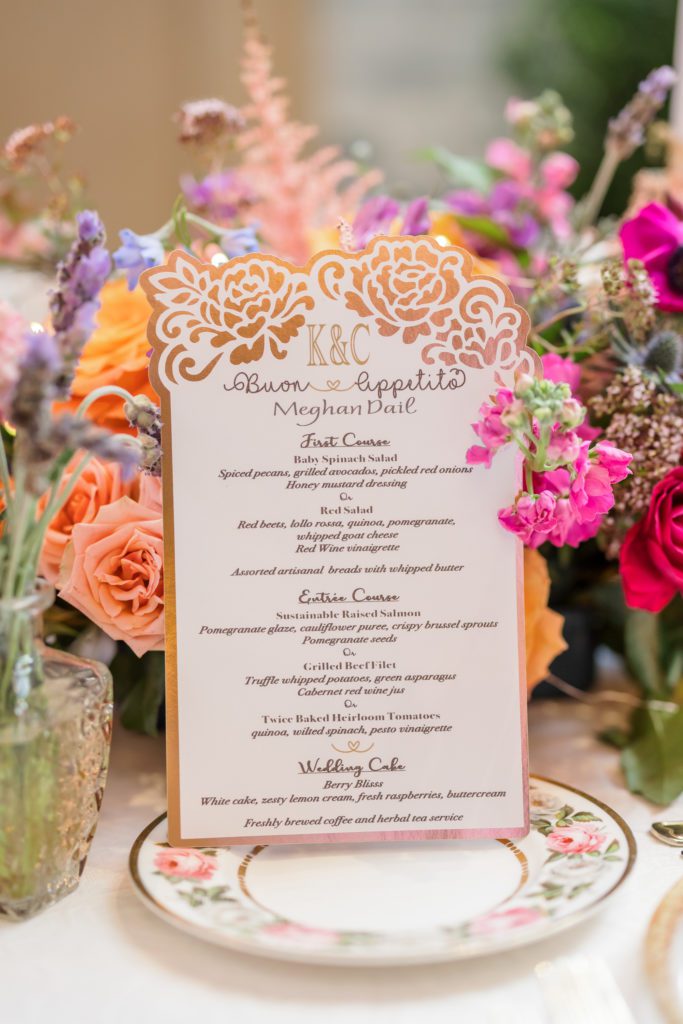 elegant and simple white and flower dinner menu with flowers around it