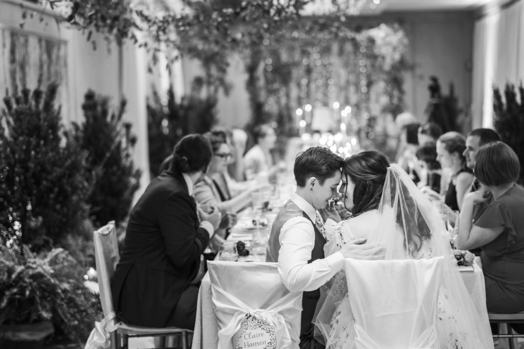 black and white portrait of brides embracing and happy at reception