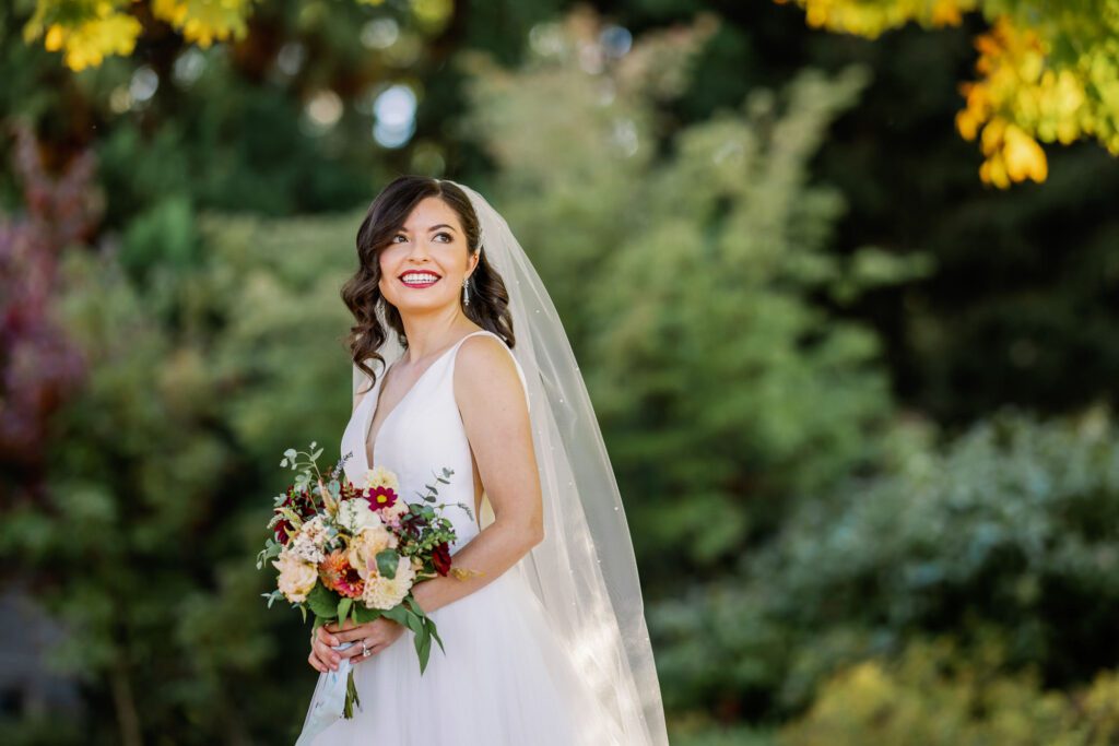 bride holding bouquet and smiling while looking at scenery