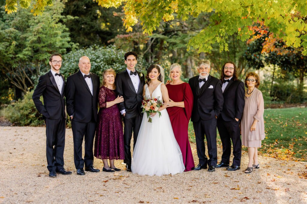 bride and groom smiling with family during bridal portraits