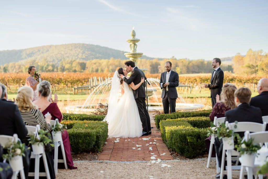 bride and groom kissing at wedding ceremony as husband and wife