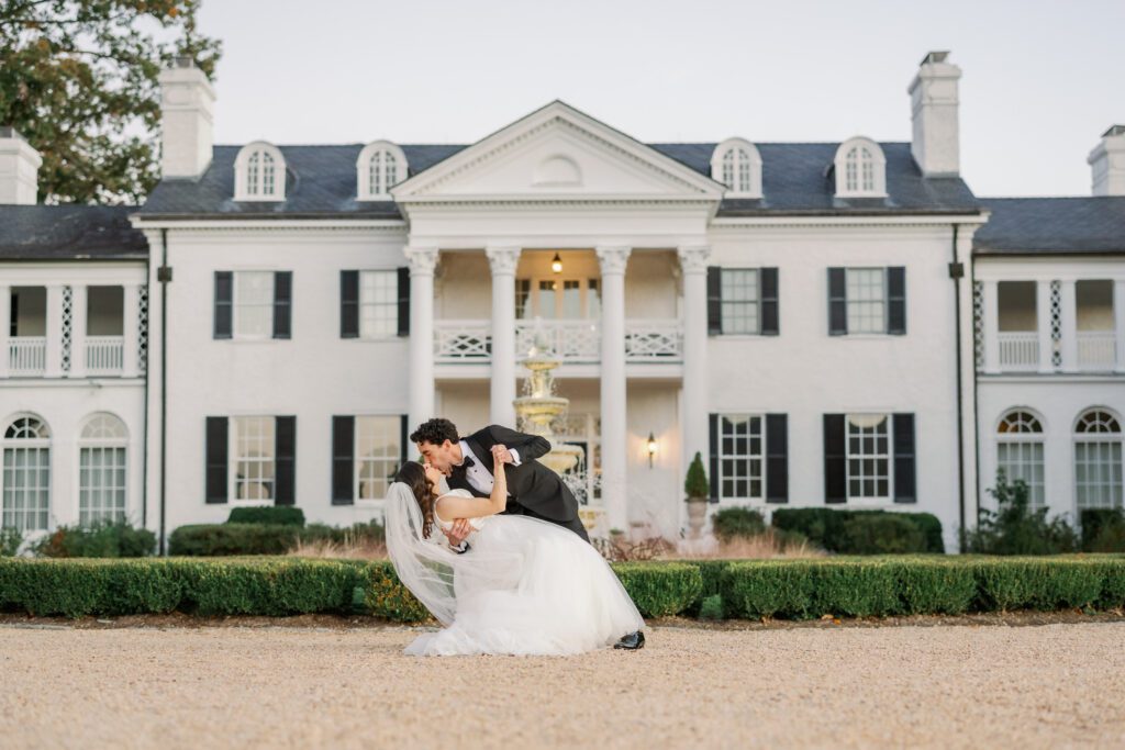 bride and groom dip kiss in front of Keswick Vineyards