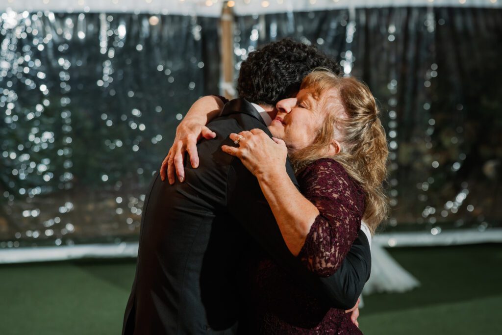 groom hugging mother after dance together