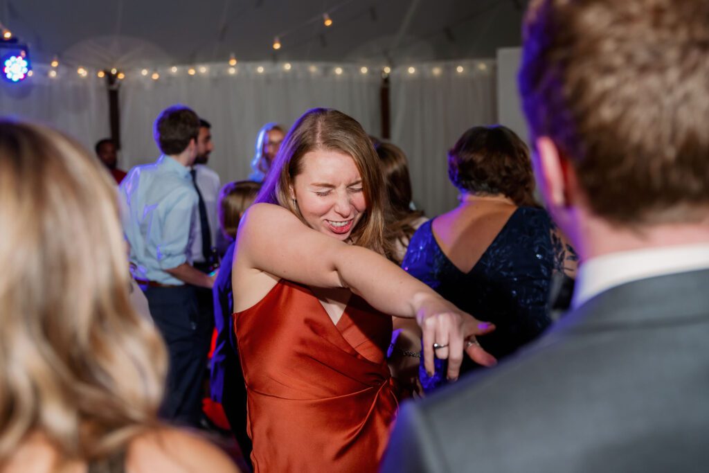 woman wearing rust dress dancing and singing