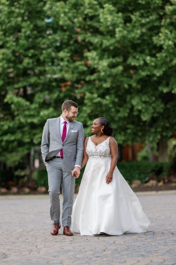 Happy couple walking hand in hand after multi-cultural wedding ceremony