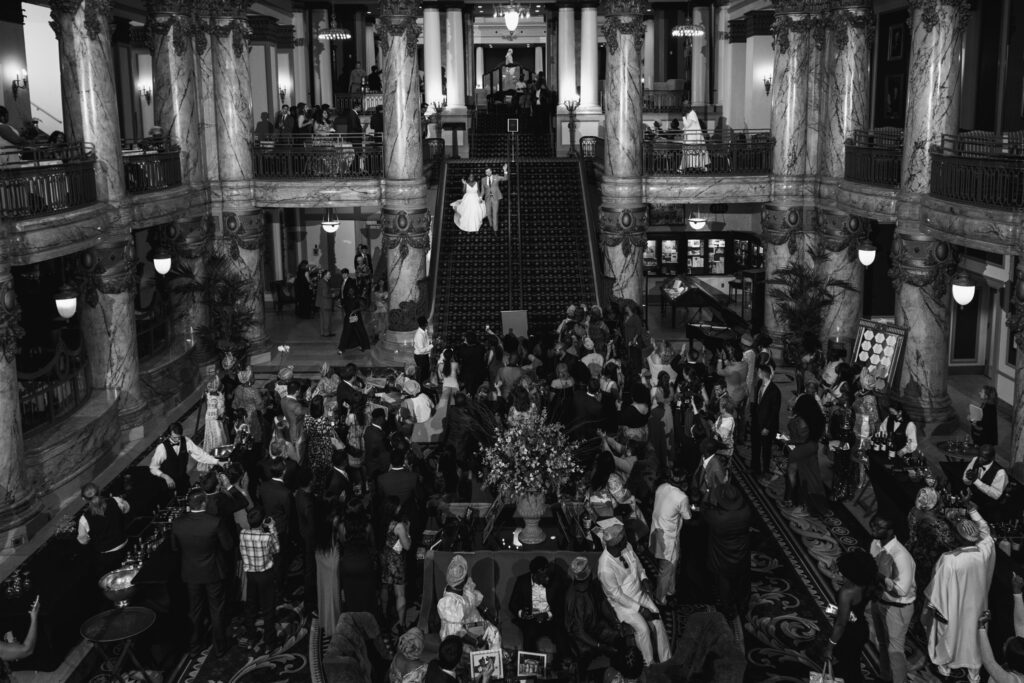 Bride and groom walking down stairs to meet guests for reception after Nigerian-American Wedding ceremony