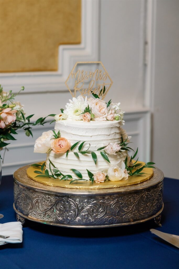Two tier wedding cake with flowers and cake topper