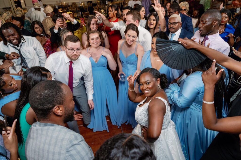 Bride and groom dancing with guests surrounding them