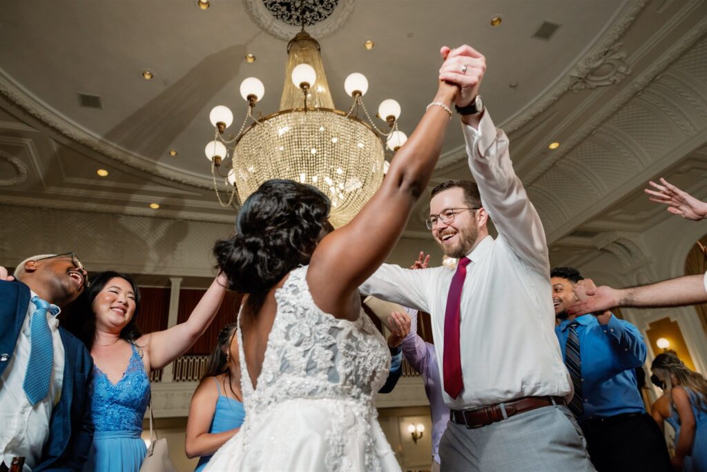 Bride and groom holding hands and dancing together