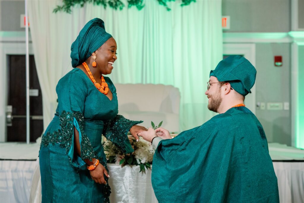 Groom putting ring on bride's finger