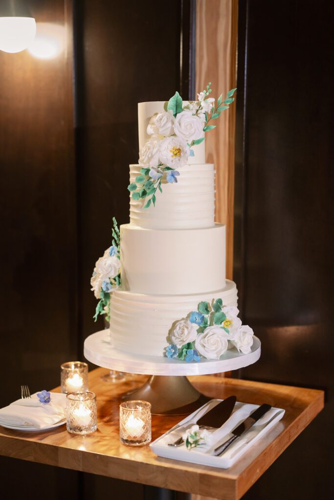 Four tiered wedding cake with flowers throughout