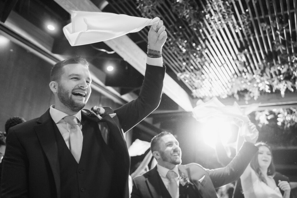 Guests waving white napkins in air to greet the bride and groom